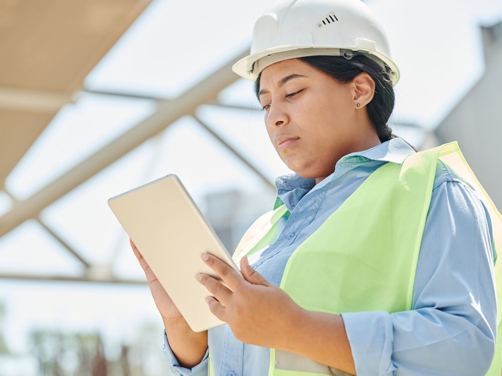Conductrice de travaux avec tablette sur un chantier, formation anglais du batiment et travaux publics